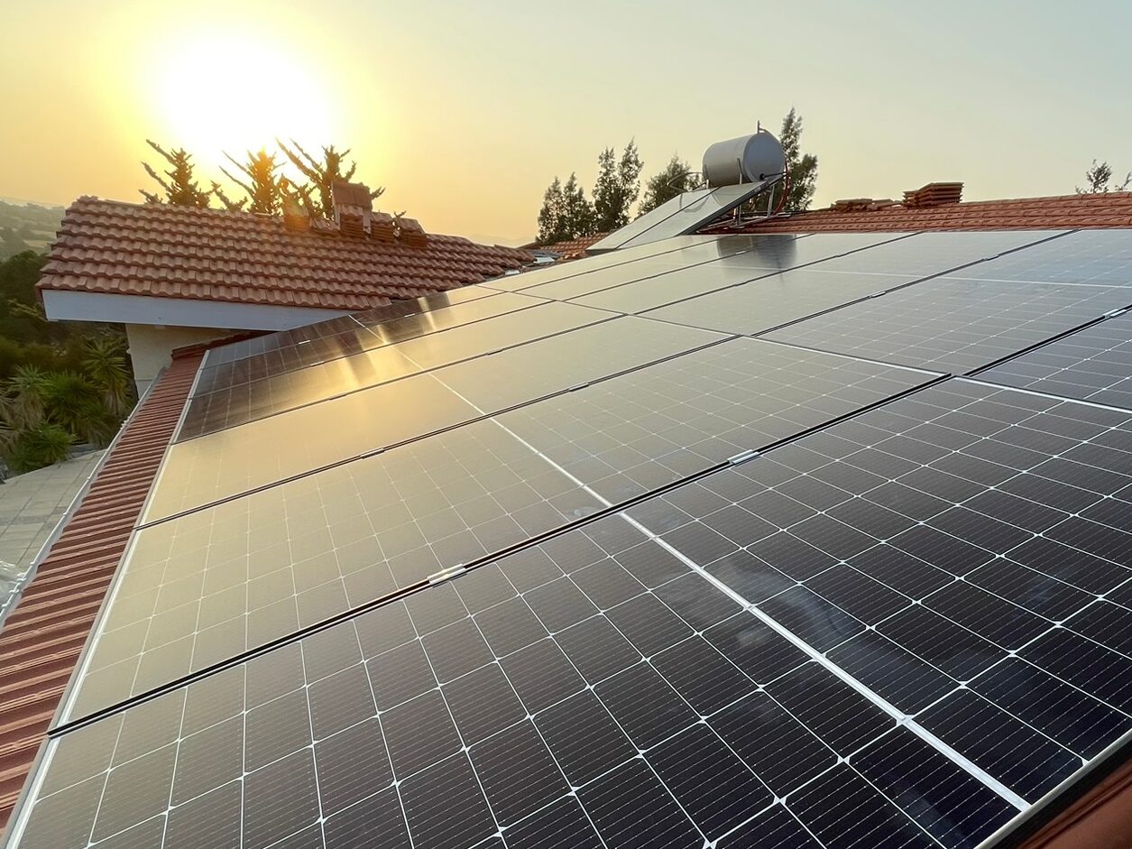 Photovoltaic system on tiled roof with the sun setting in the background